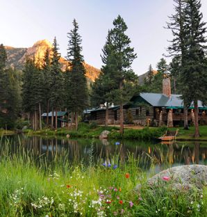 A Lake With A House And Trees Around It