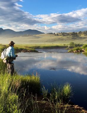 A Man Standing Next To A Pond