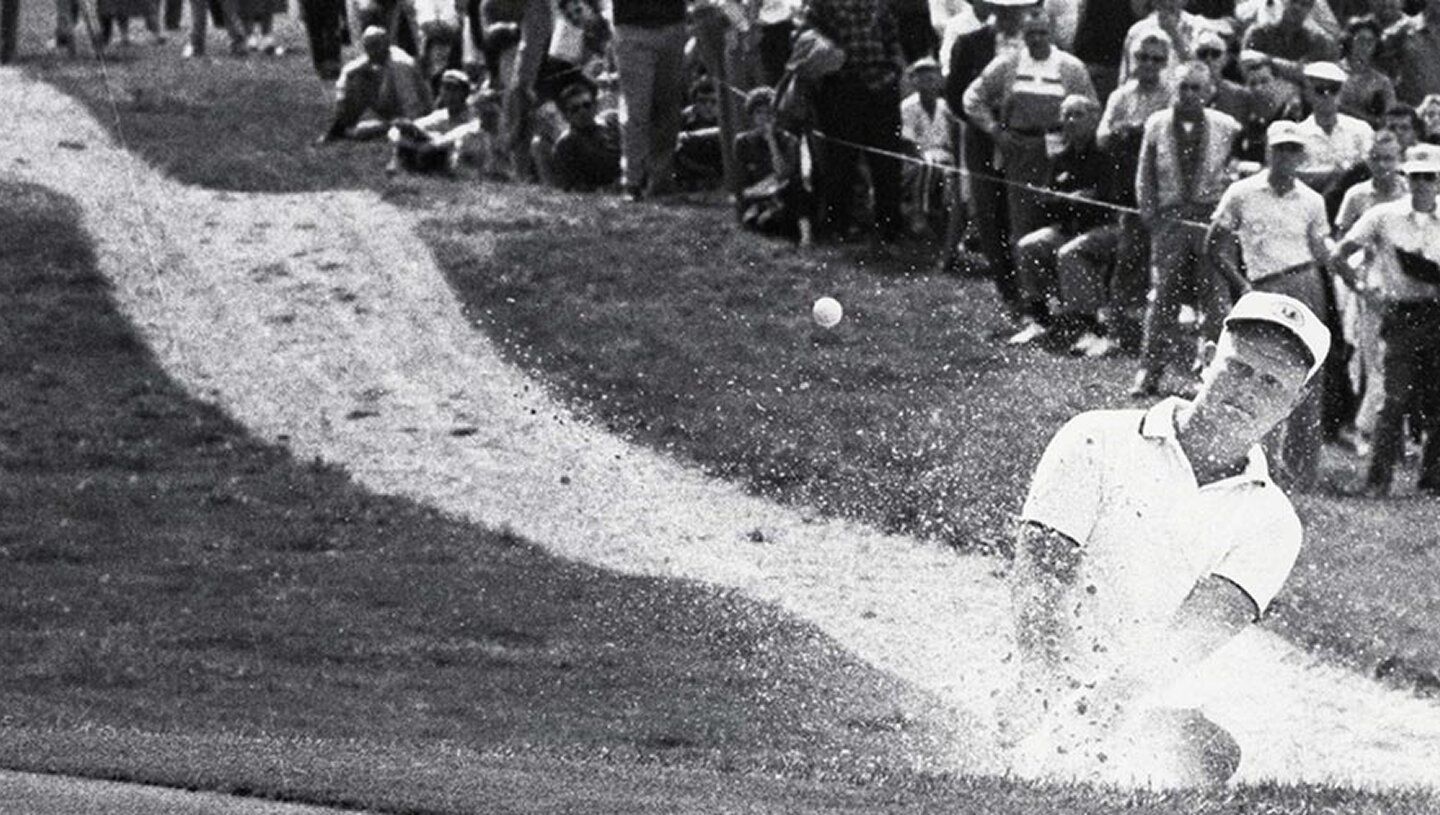 A Man Hitting A Ball With A Bat