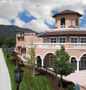 A Building With A Road And Trees