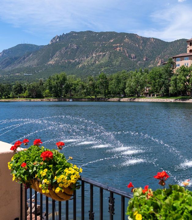 A Body Of Water With Flowers And A Building In The Background